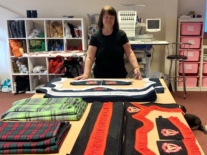 Caroline Brady standing behind her work of curtains and materials