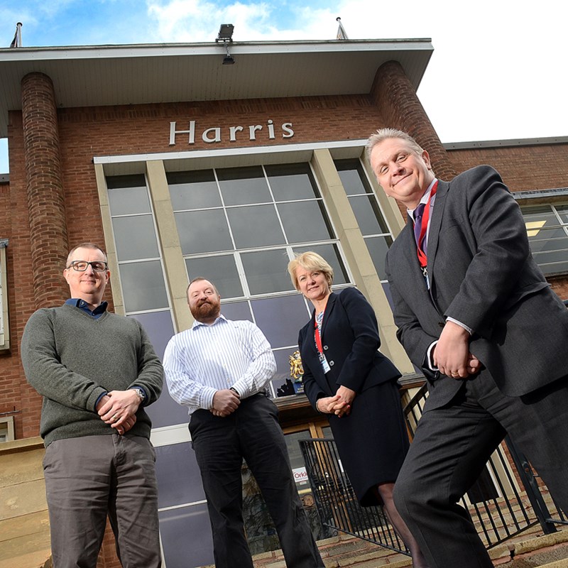 4 people outside harris building