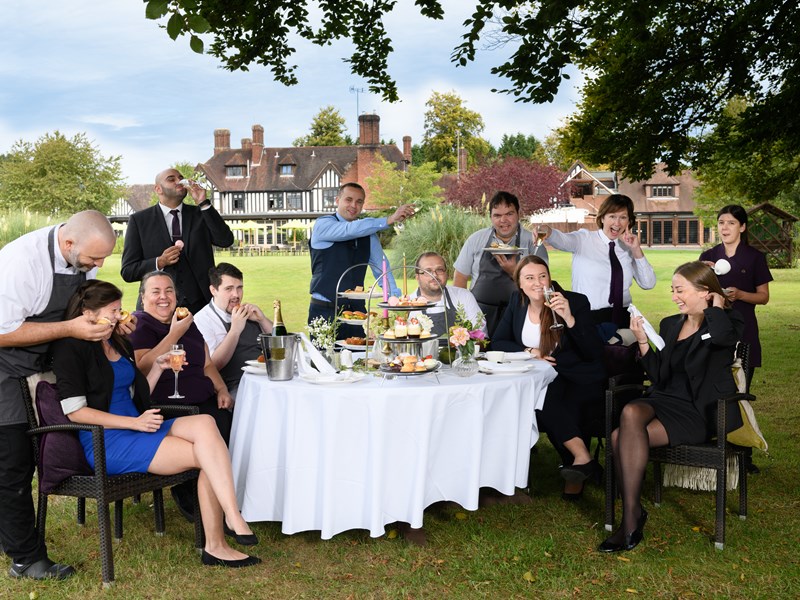 multiple people sat around table with cakes