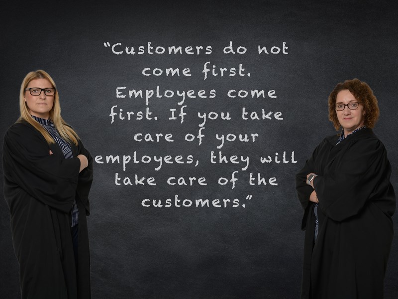 2 ladies posing in front of quote