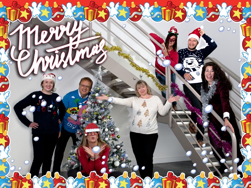 group of people gathered on stairs with christmas decorations