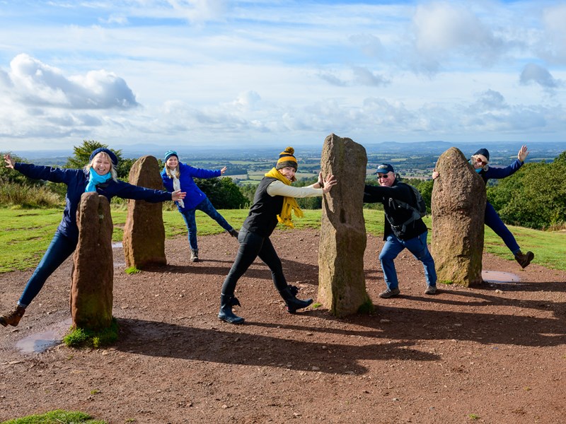 5 people outside in hiking clothes posing by large rocks
